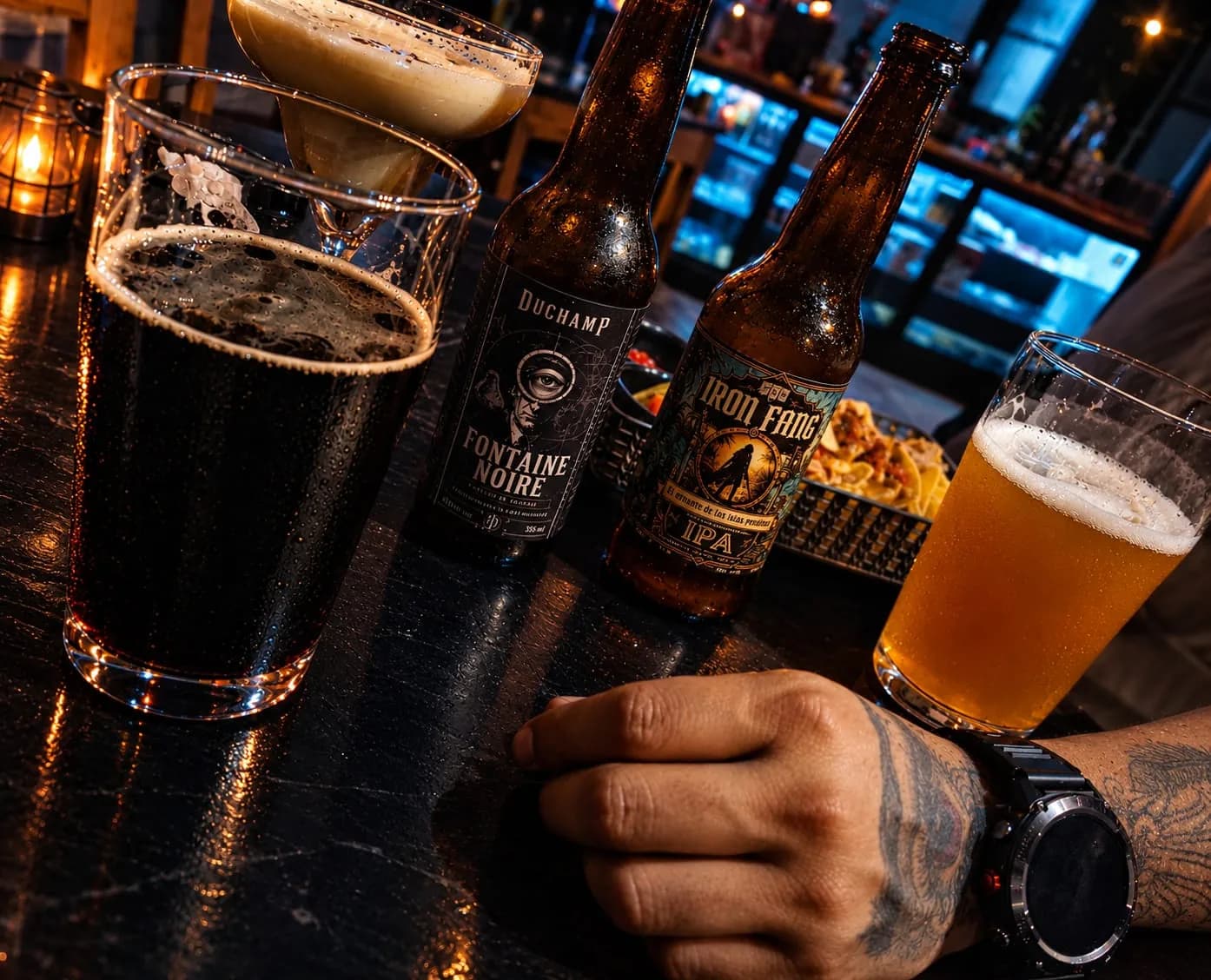 Mesa de bar de noche con una stout oscura, una IPA servida y botellas de Iron Fang compartidas entre amigos.
